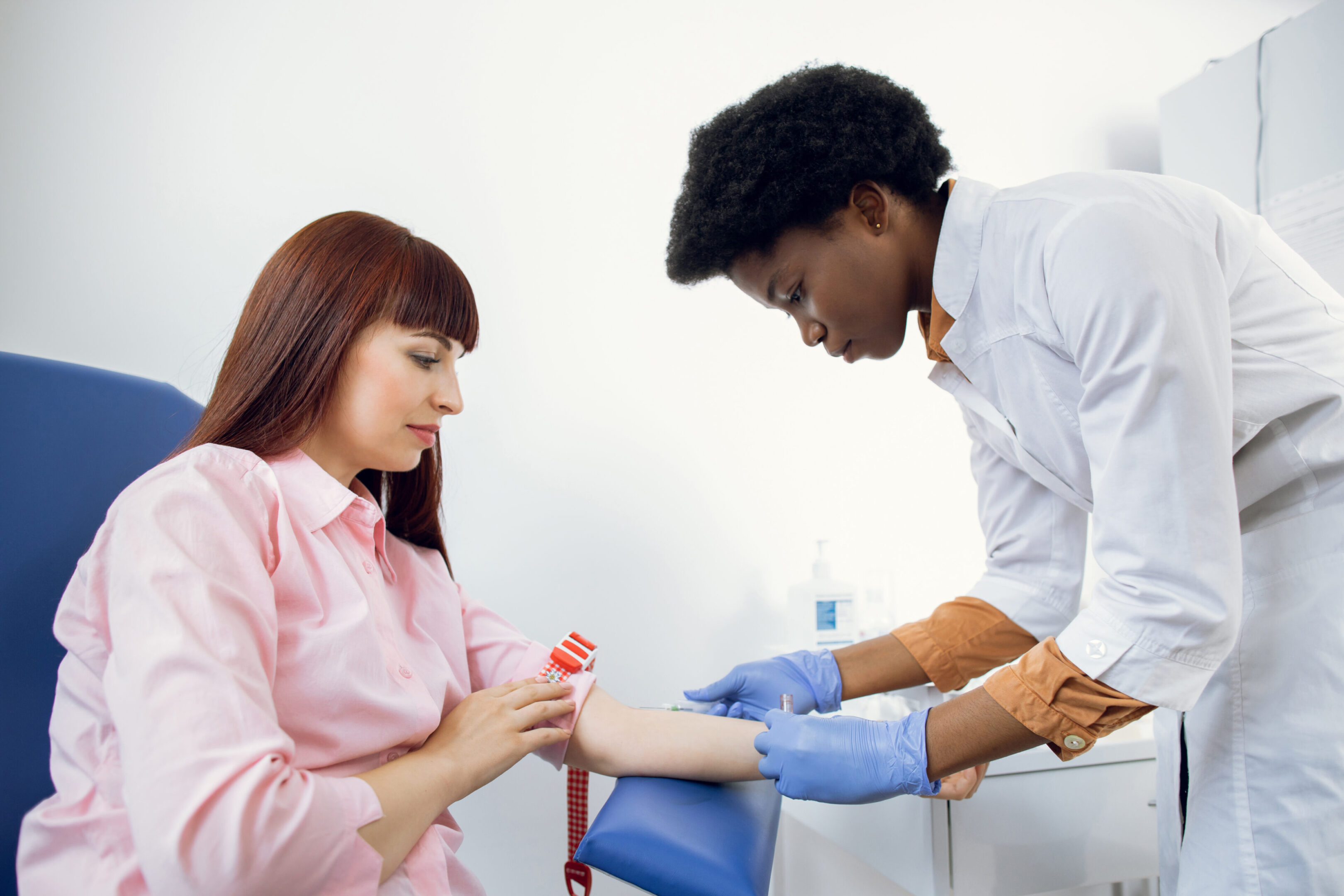 Preparation for blood test. Beautiful young African woman doctor in white medical uniform ready to take blood sample from patient's vein. Preparation for blood test. Beautiful young African woman doctor in white medical uniform ready to take blood sample from patient's vein
