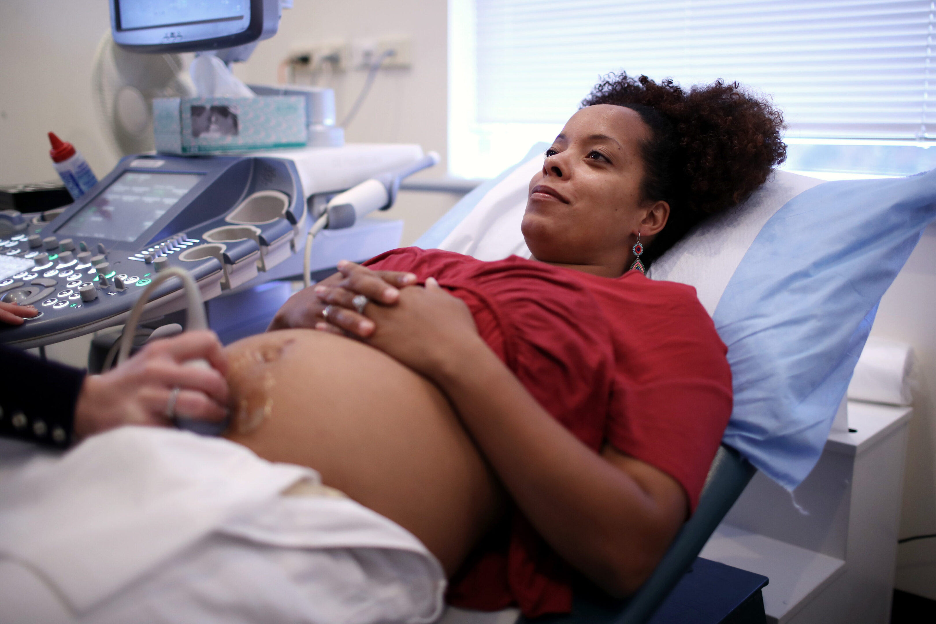 Happy Pregnant Woman Having Ultrasound Scan A happy, pregnant woman has an ultrasound scan with a doctor